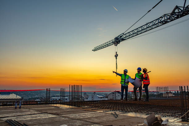 project managers looking over the side of a large building under construction with a crane in the background